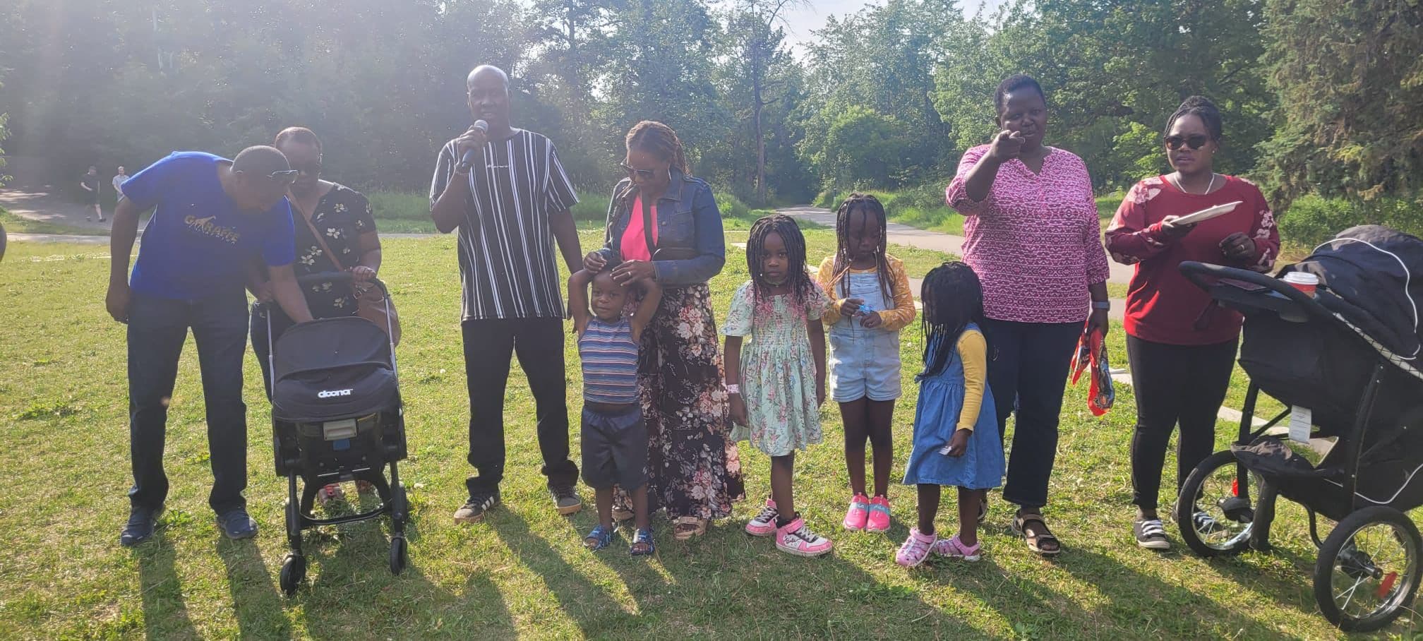 SetCan's chairman addressing members at the summer barbecue, families gathered around him
